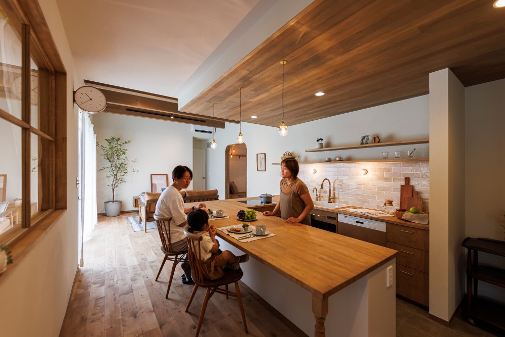 木のカフェキッチンに家族が集う。三角屋根の平屋